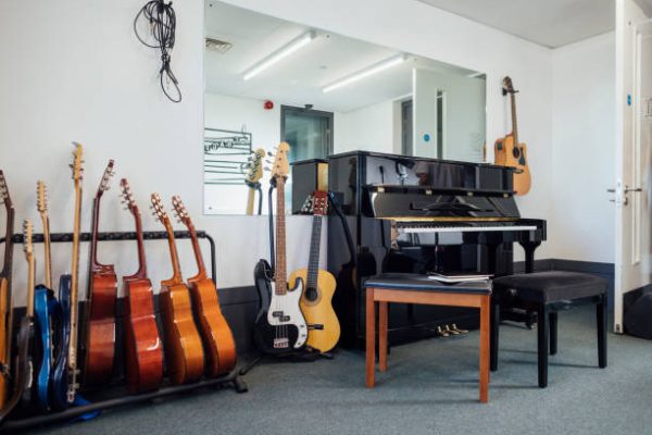 istockphoto-1457976868-612×612 A music classroom filled with a piano and guitars in a secondary school in the North East of England. There is no people.